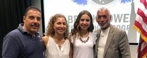 Payton Barnwell with three other guests at a Brooke Owens Fellowship event, the programme banner behind them.
