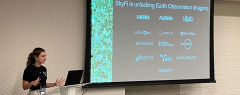 Payton Barnwell presenting beside a slide reading “SkyFi is unlocking Earth Observation imagery.”